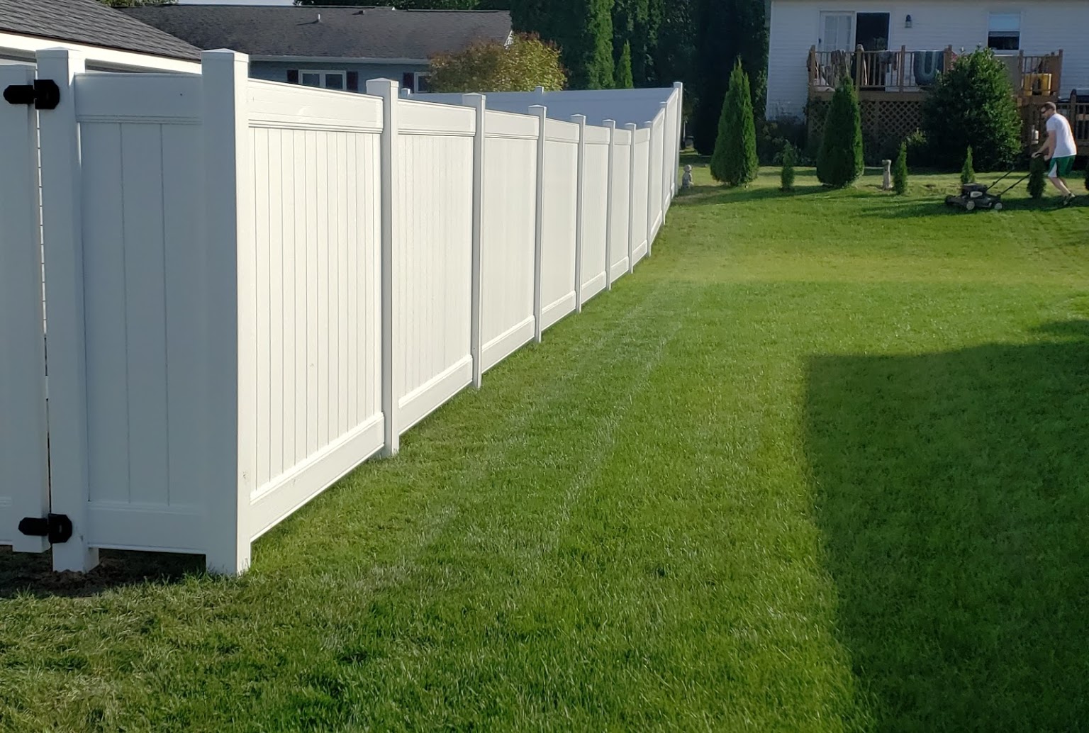 White vinyl privacy fence installed along a residential property