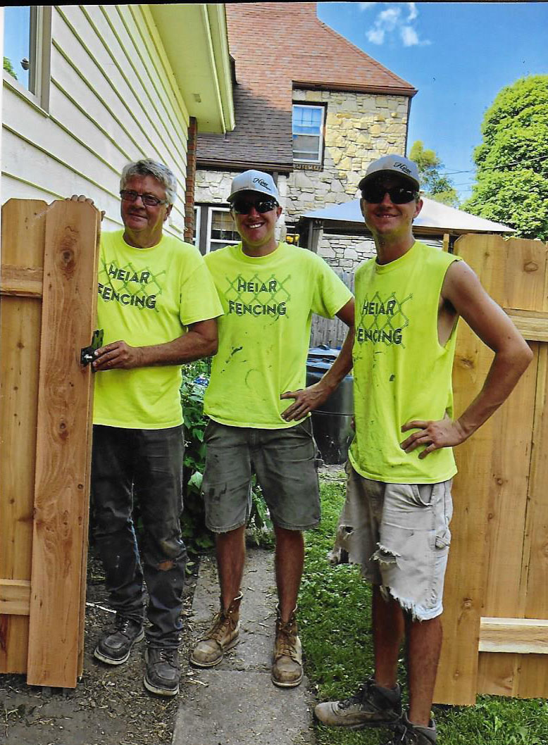 The Heiar Fencing family team standing beside a cedar gate installation