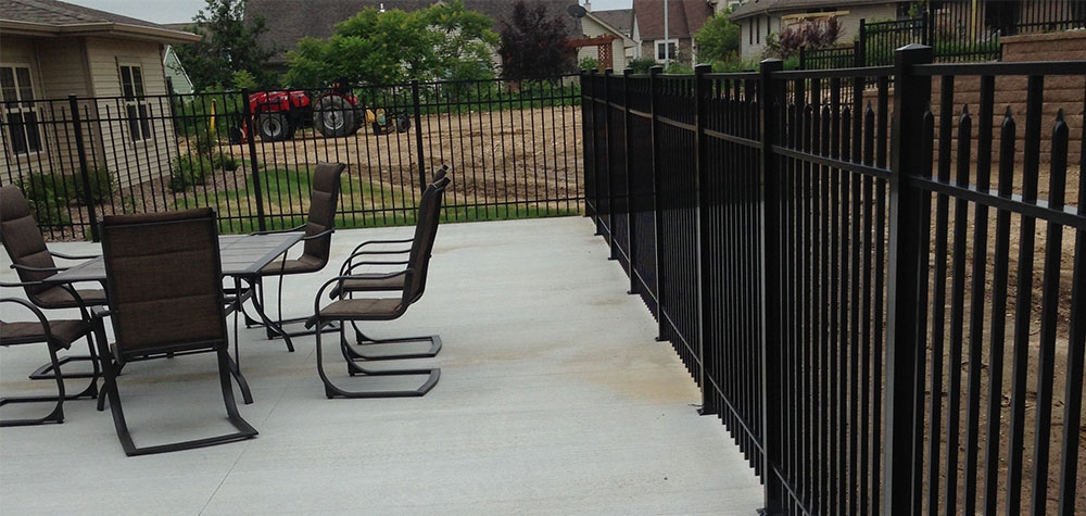 Black ornamental fence lining a residential patio